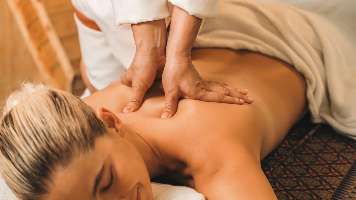 A massage therapist working with a client