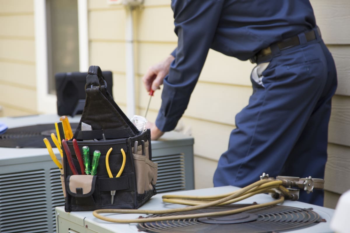 An HVAC technician servicing an AC unit